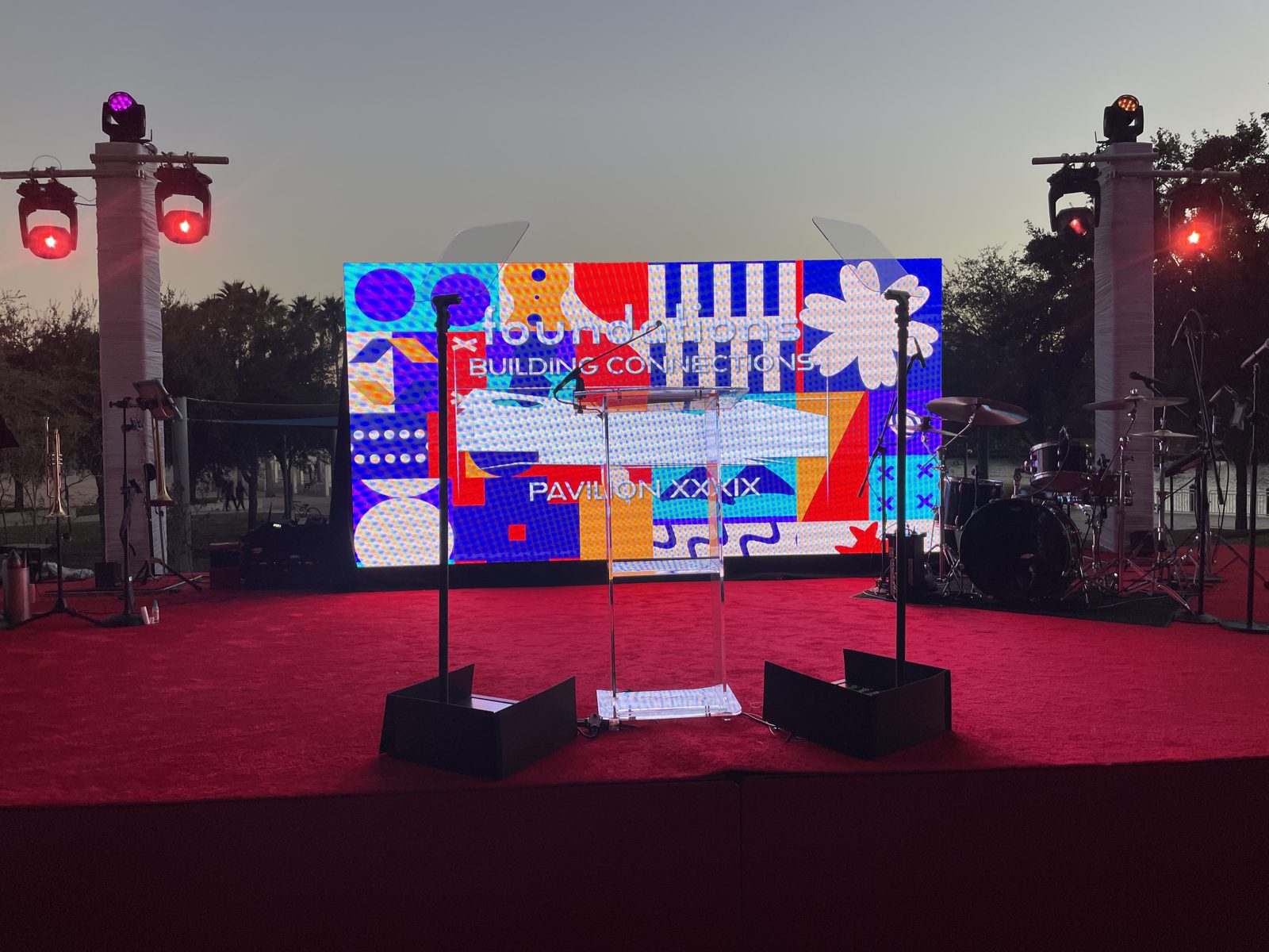 Outdoor LED-wall stage at dusk with presidential teleprompter glass