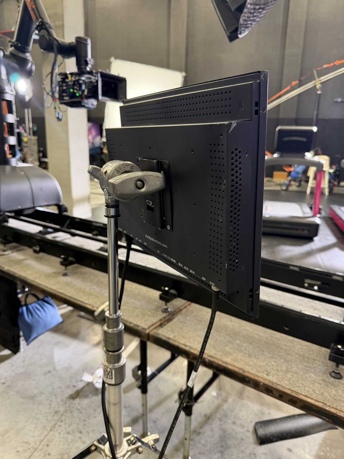 Teleprompter monitor on a stand beside camera dolly track